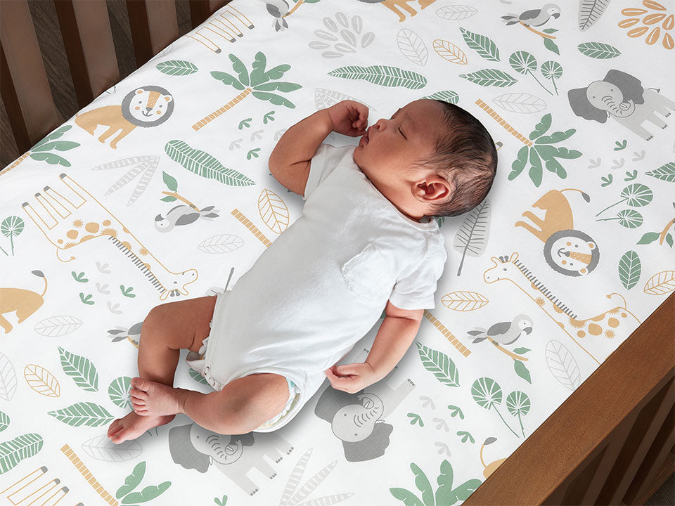 Baby sleeping on soft Jungle Friends crib sheet