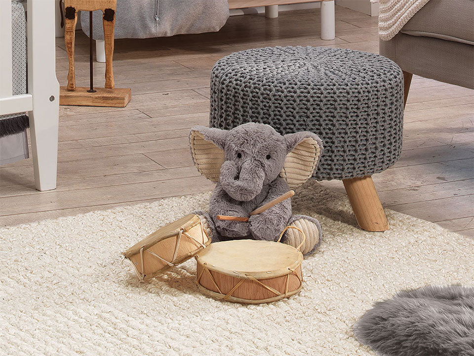 Plush stuffed animal Elephant Jett playing drums in a baby nursery
